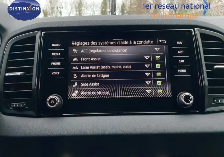 Écran central du tableau de bord du Skoda Karoq gris argent 2025 affichant les réglages d’aide à la conduite.