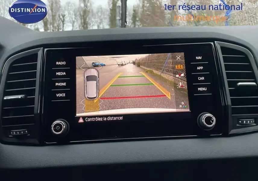 Écran central de la Skoda Karoq 2025 gris argent, vue de la caméra de recul avec guidage de trajectoire.