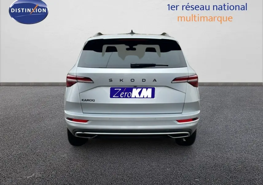 Vue arrière d'un Skoda Karoq gris argent métal 2025, avec feux LED et double sortie d'échappement intégrée.