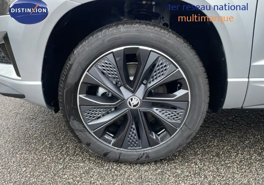 Gros plan sur la roue avant droite avec jante noire et gris argent métallisé du Skoda Karoq 2025.