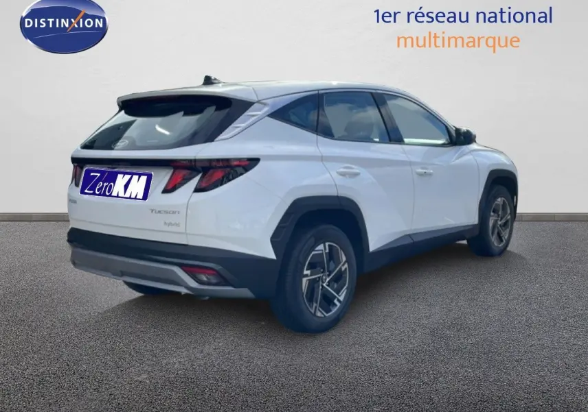 Vue 3/4 arrière droite d'un Hyundai Tucson blanc Atlas 2026 avec feux arrière LED et jantes bi-ton.