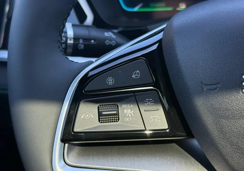Gros plan sur les commandes du volant noir du BYD SEAL U 1.5 DM-i, avec boutons de régulateur et assistance.