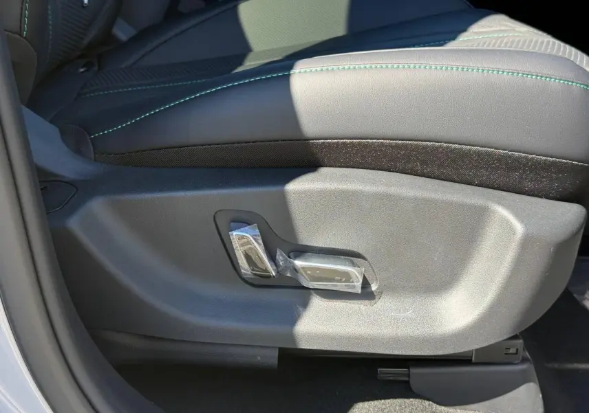 Gros plan sur le réglage électrique du siège conducteur en cuir noir avec surpiqûres vertes du BYD SEAL U 2026.