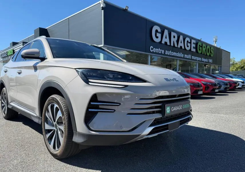 Vue 3/4 avant gauche du BYD SEAL U 1.5 DM-i 218ch Boost en Boundless Cloud métallisé avec jantes alu, devant un garage.