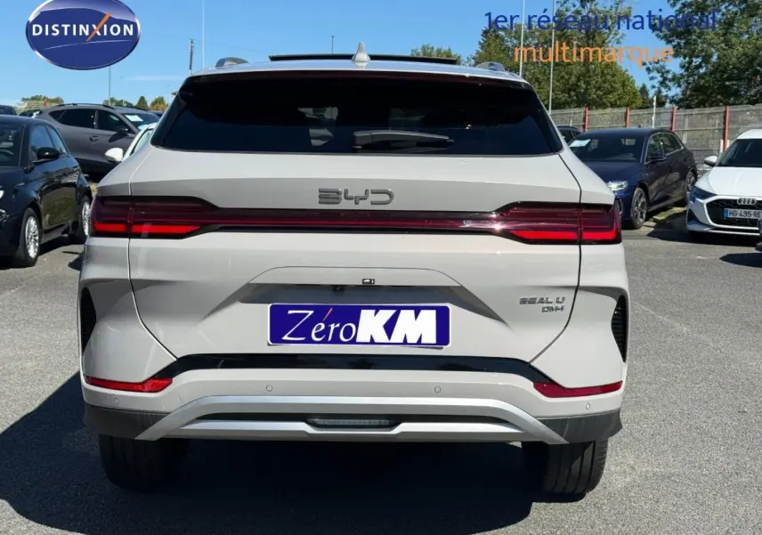 Vue arrière d'un BYD SEAL U hybride rechargeable en blanc métallisé avec feux LED et logo distinctif sur parking.