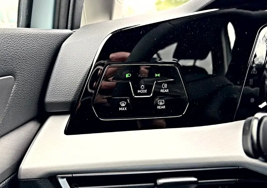 Détail du panneau de commandes d’éclairage et désembuage côté gauche intérieur d’une Volkswagen Golf bleu glacier 2026.