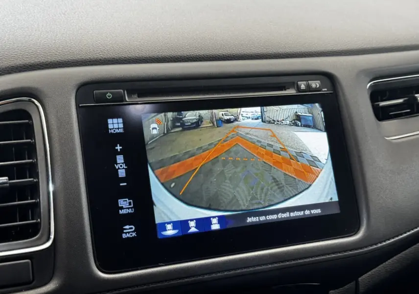 Écran tactile intérieur montrant la caméra de recul avec guidage orange sur Honda HR-V blanc, vue arrière.