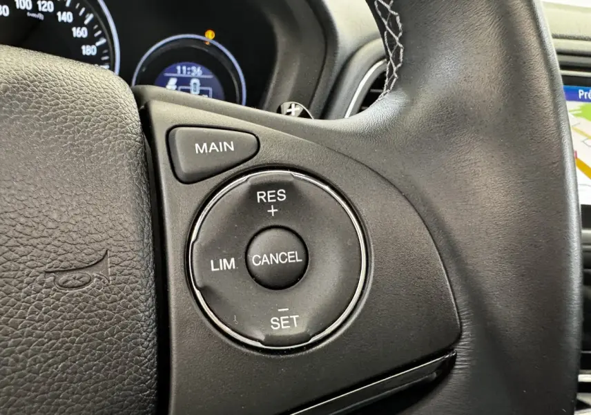 Gros plan sur les commandes du régulateur de vitesse au volant cuir noir du Honda HR-V 1.5 i-VTEC 130 Exclusive.