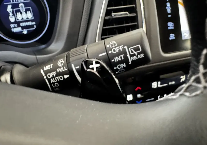 Gros plan sur la commande d'essuie-glace et palette de changement de vitesse dans le tableau de bord noir du Honda HR-V blanc 2019.