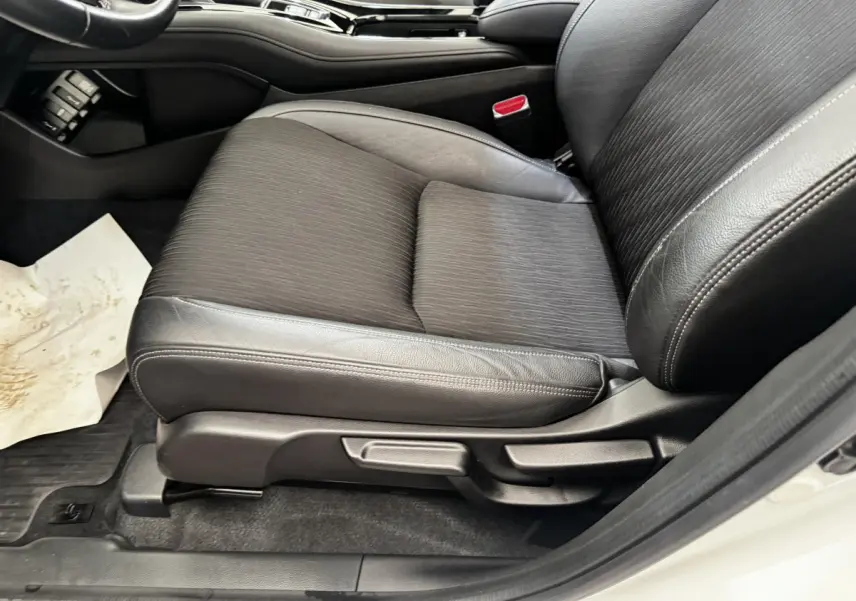 Gros plan sur le siège avant droit noir en cuir et tissu du Honda HR-V blanc, avec réglages manuels visibles.