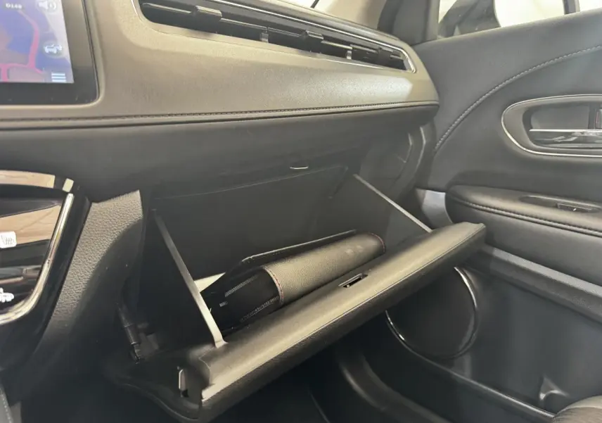 Intérieur du Honda HR-V 1.5 i-VTEC 130 Exclusive 2019, vue côté passager sur la boîte à gants ouverte noire.