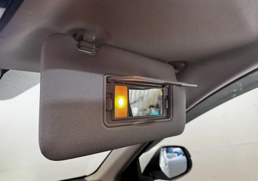 Détail intérieur du pare-soleil côté conducteur avec miroir éclairé dans un Honda HR-V blanc de 2019.