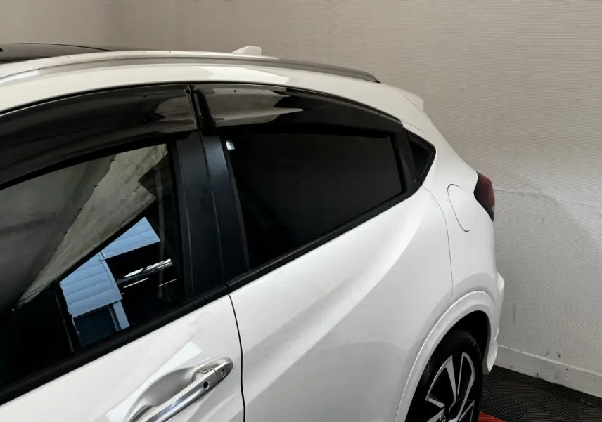 Vue latérale droite du Honda HR-V blanc 2019, mettant en valeur la porte arrière et la jante noire à motifs argentés.