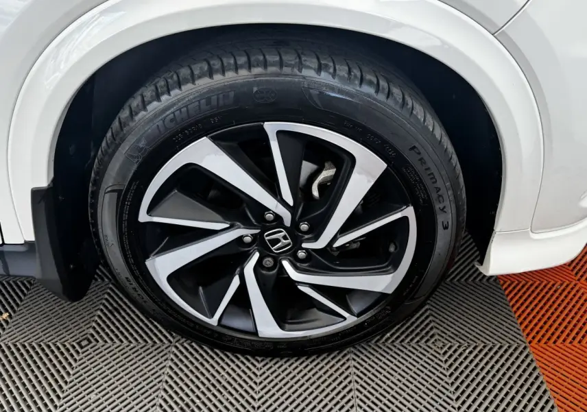 Gros plan sur la roue avant droite du Honda HR-V blanc, mettant en valeur la jante alliage bicolore et le pneu Michelin.