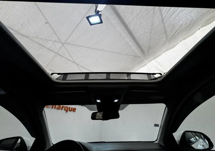 Vue intérieure du toit ouvrant électrique en verre du Honda HR-V blanc, avec tableau de bord et rétroviseurs visibles.