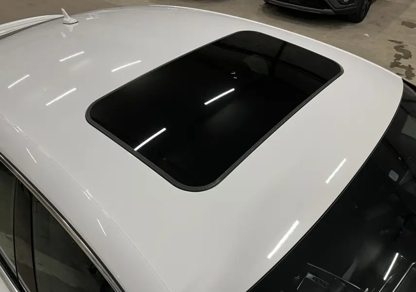 Toit ouvrant panoramique noir sur Audi A5 Sportback blanche vue de dessus en intérieur.