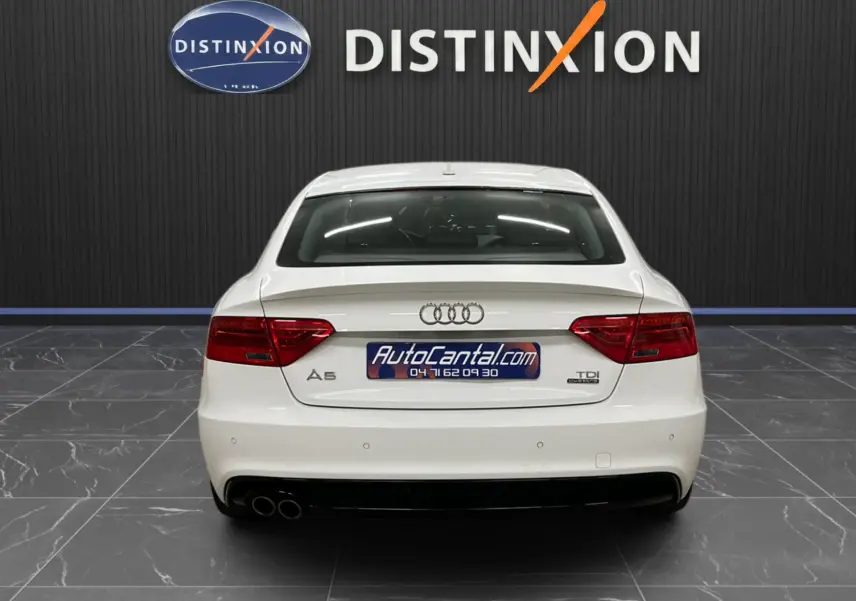 Vue arrière d'une Audi A5 Sportback blanche de 2015 avec double sortie d'échappement et logo TDI quattro visible.