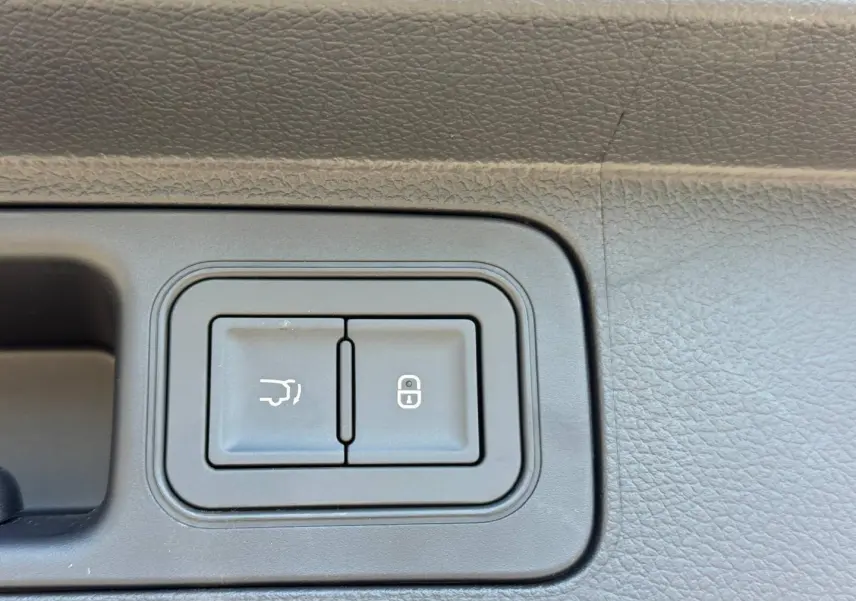 Gros plan sur les boutons d'ouverture du coffre et de verrouillage sur la portière intérieure noire du BYD SEAL U.
