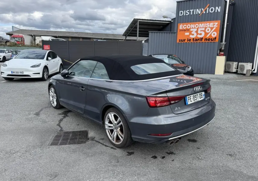 Audi A3 Cabriolet gris vue 3/4 arrière droit avec capote noire et jantes sport 5 branches.