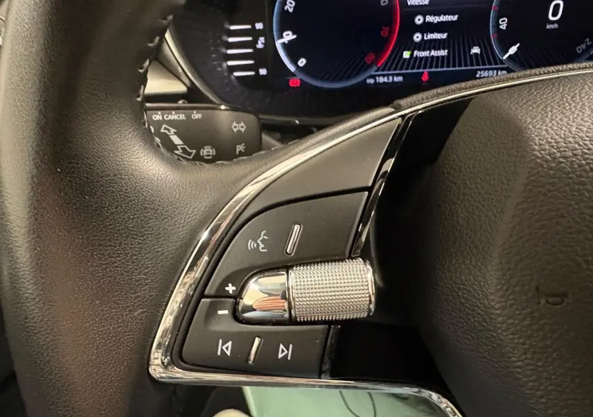 Gros plan sur les commandes au volant côté gauche de la Skoda Fabia 2023 gris graphite avec tableau de bord numérique.