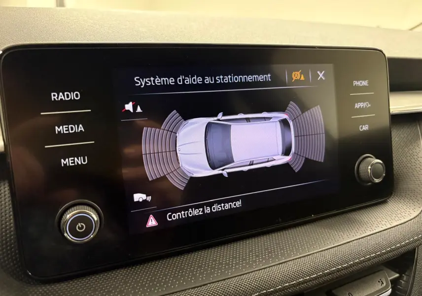 Écran du système d'aide au stationnement de la Skoda Fabia 2023, affichant une vue aérienne du véhicule gris graphite.