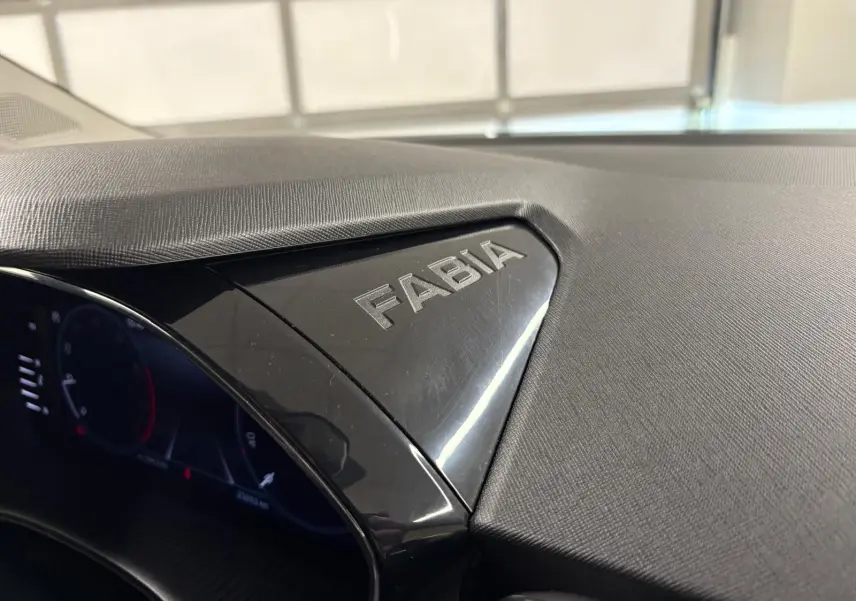 Gros plan sur le tableau de bord noir brillant avec le logo Fabia gravé, intérieur d'une Skoda Fabia 2023.