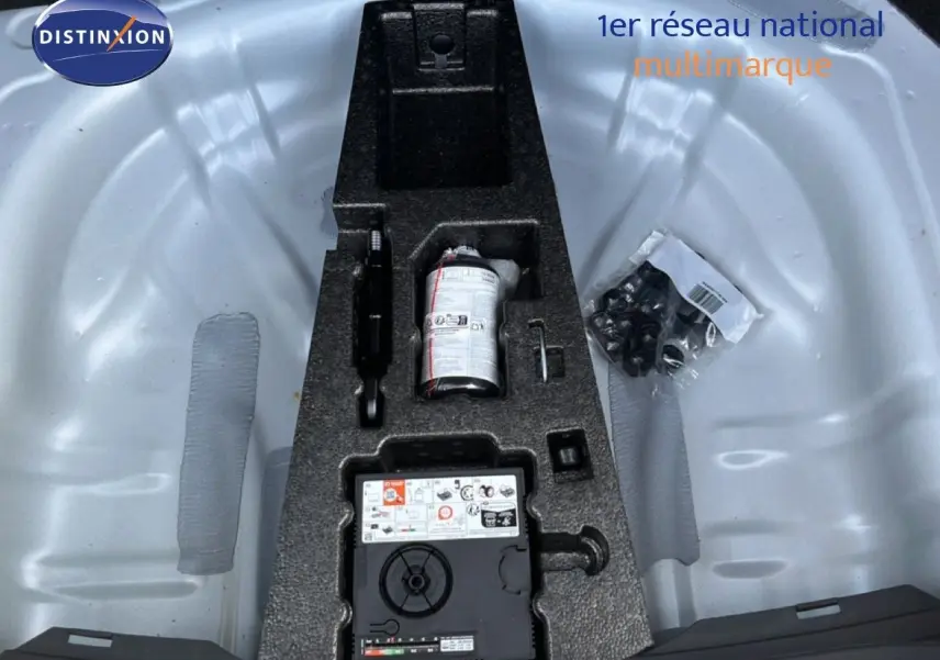 Vue plongeante sur le coffre avec kit de réparation pneu et accessoires dans un SEAT LEON blanc neige 2025.