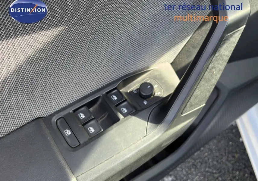 Détail des commandes de lève-vitres et rétroviseurs sur la porte côté gauche d’une SEAT LEON blanc neige 2025.