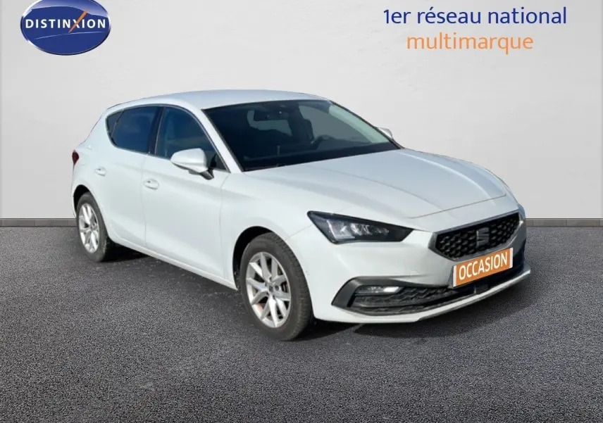 SEAT Leon blanc neige vue 3/4 avant droit, avec calandre noire et jantes alliage argentées.