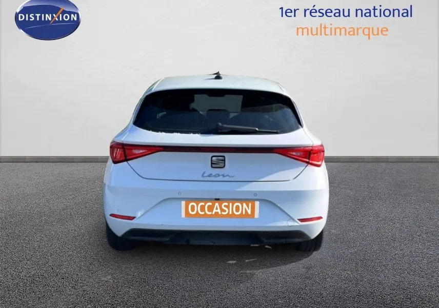 Vue arrière d'une SEAT Leon blanche neige 2025 avec feux LED et plaque d'immatriculation "OCCASION".