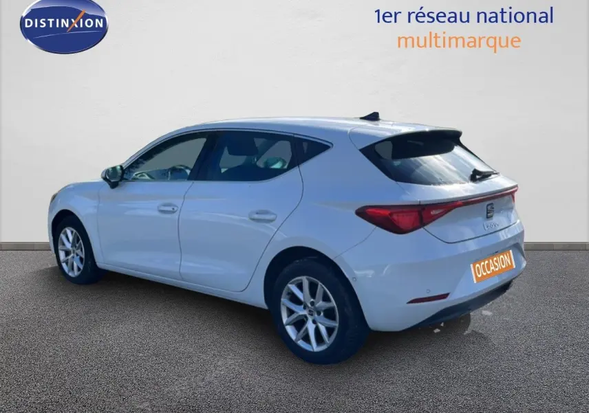 Vue 3/4 arrière droite d'une SEAT Leon blanche neige, compacte avec feux arrière LED et jantes alliage.