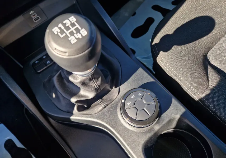 Gros plan sur la boîte manuelle et la molette de sélection 4x4 dans l’habitacle du Ford Ranger Super Cabine gris.