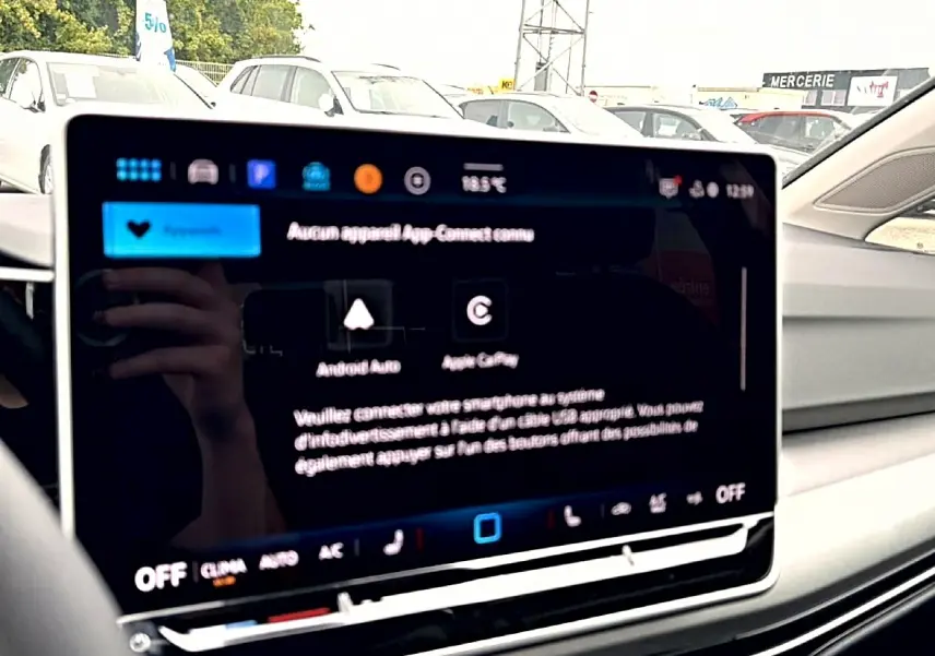 Écran tactile central du Volkswagen Golf 2026 noir, affichant les options Android Auto et Apple CarPlay, vue intérieure côté passager.
