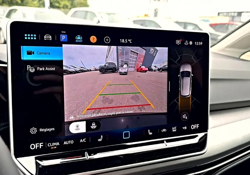 Écran tactile intérieur de Volkswagen Golf noir 2026 montrant l'assistance au stationnement avec caméra de recul active.