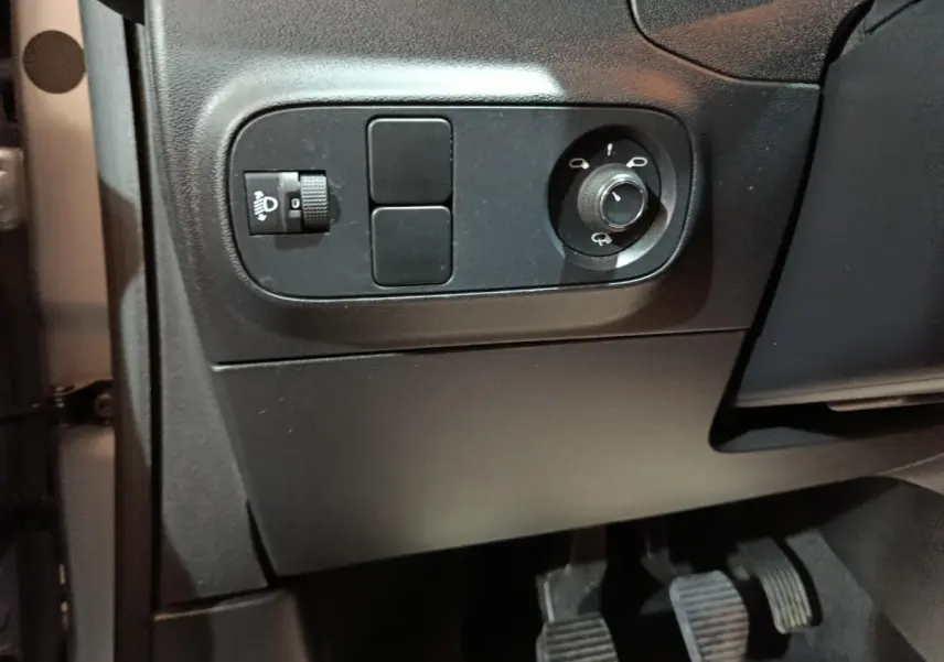 Détail des commandes d’éclairage et réglage des rétroviseurs côté conducteur dans une Citroën C3 gris clair 2024.