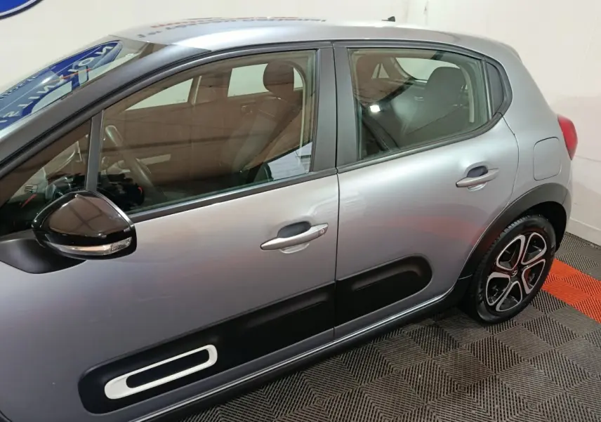 Vue latérale droite d'une Citroën C3 gris clair 2024 avec protections de porte noires et jantes stylisées.