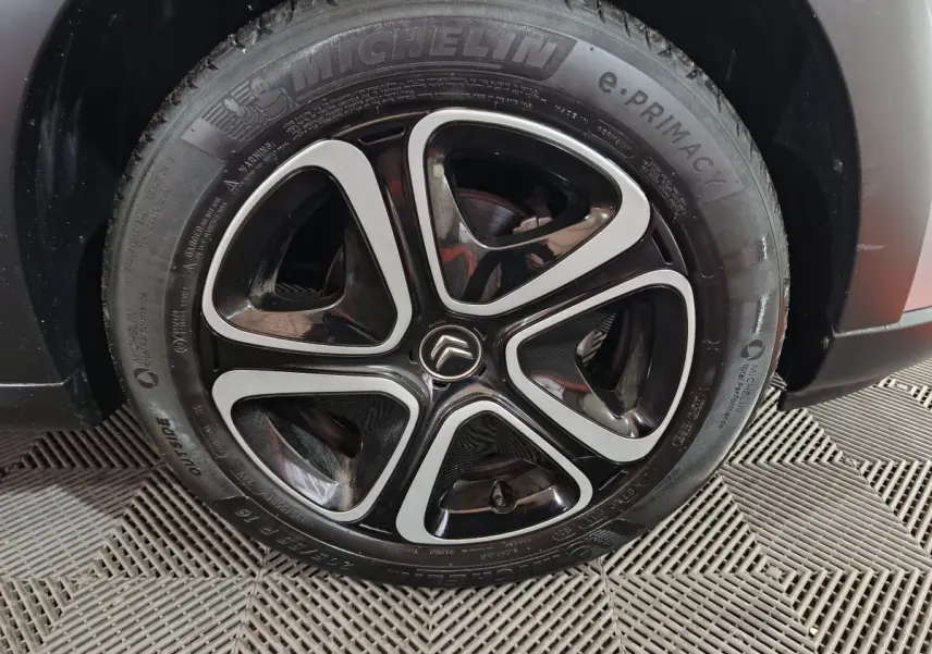 Gros plan sur la roue avant droite gris clair de la Citroën C3 2024 avec jante alliage noire et argentée distinctive.