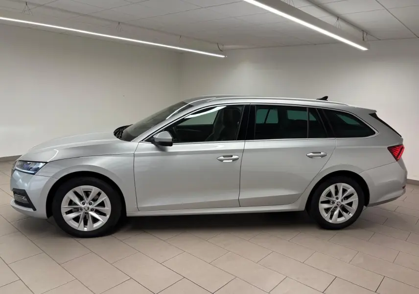 Vue latérale droite d'une Skoda Octavia Combi gris argent 2023 avec jantes alliage et feux arrière LED distinctifs.