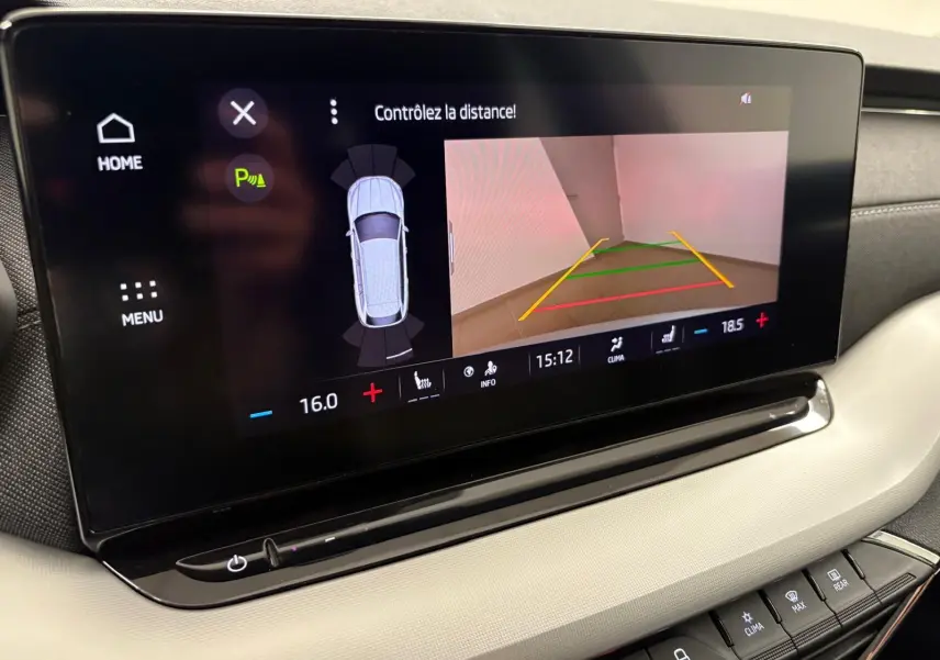 Écran tactile central de la Skoda Octavia Combi gris argent 2023 montrant la caméra de recul et les commandes climatiques.