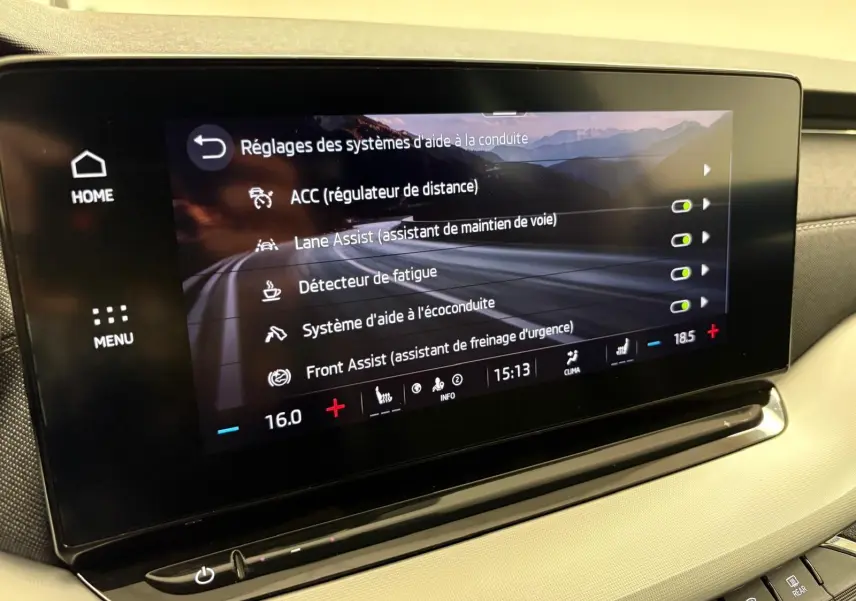 Écran tactile intérieur du Skoda Octavia Combi gris argent 2023 affichant les réglages d'aide à la conduite.