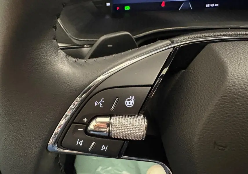 Gros plan sur les commandes gauche du volant en cuir noir de la Skoda Octavia Combi gris argent 2023.