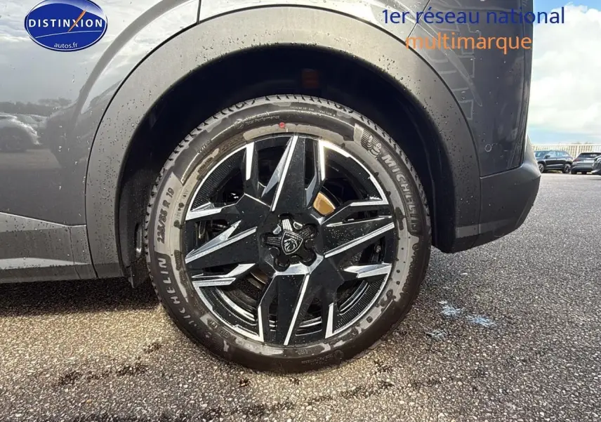 Gros plan sur la roue arrière droite du Peugeot 3008 gris titane, mettant en valeur la jante alu au design moderne.