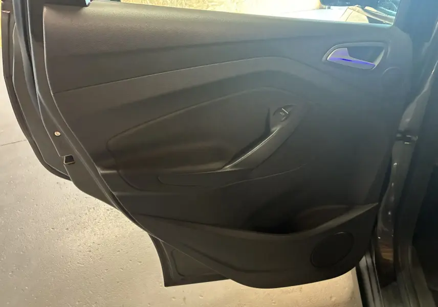 Gros plan sur la porte arrière droite intérieure noire du Ford C-MAX gris 2015 avec poignée et commande de vitre.