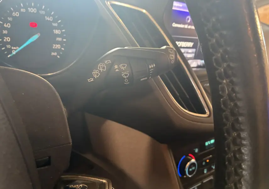 Gros plan sur la manette d'essuie-glace à gauche du volant dans l'habitacle gris noir du Ford C-MAX 2015.