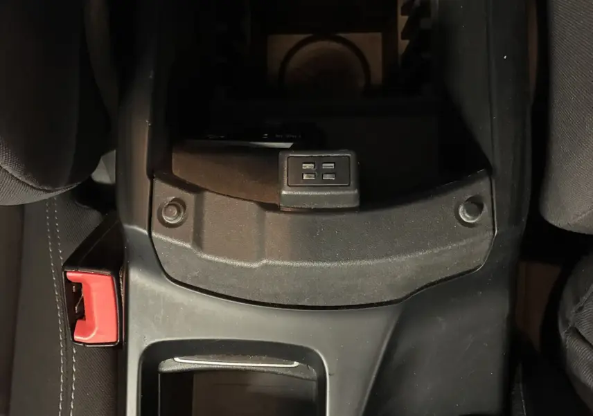 Vue plongeante sur la console centrale noire du Ford C-MAX gris 2015, avec porte-gobelets et bouton de commande visible.