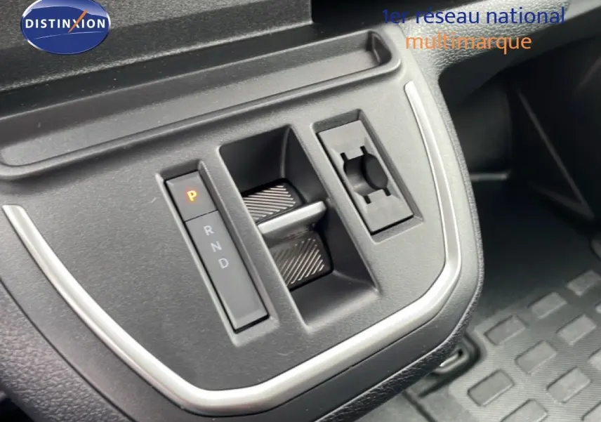 Gros plan sur la console centrale du Citroën Jumpy gris, montrant la commande de boîte automatique et le bouton de stationnement.