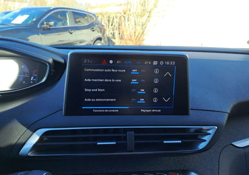 Vue intérieure du tableau de bord du Peugeot 5008 gris, avec écran tactile affichant les réglages d'aides à la conduite.