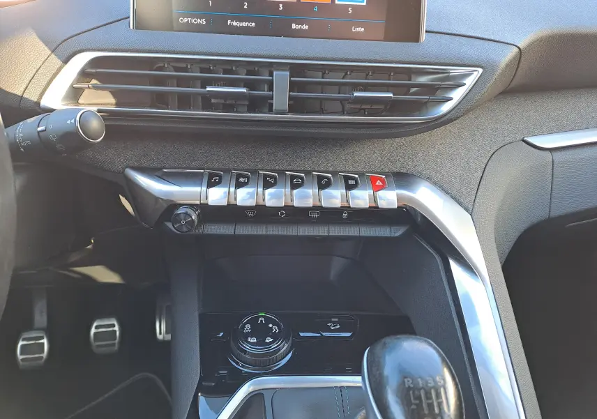 Vue rapprochée de la console centrale intérieure grise du Peugeot 5008 2019, avec levier de vitesse manuel et commandes chromées.