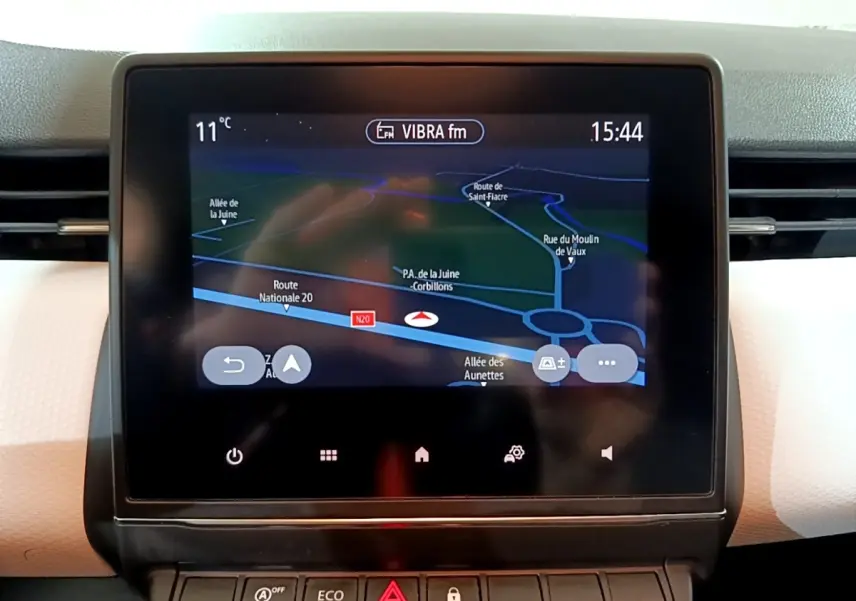 Écran tactile central affichant la navigation GPS dans l’habitacle clair d’une Renault Clio Business blanche.