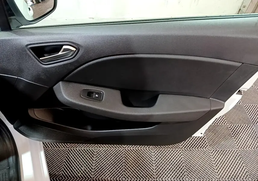 Vue intérieure côté gauche de la porte avant noire d’une Renault Clio Business blanche avec commande de vitre électrique.
